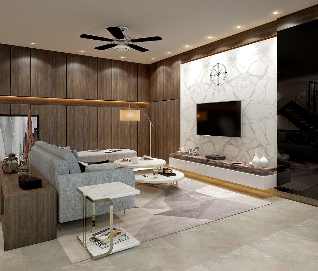 The living room composed between a fluted wood wall and a book-matched white marble media wall, with a grey sofa, round marble-topped nesting tables, a gold side table and a geometric rug