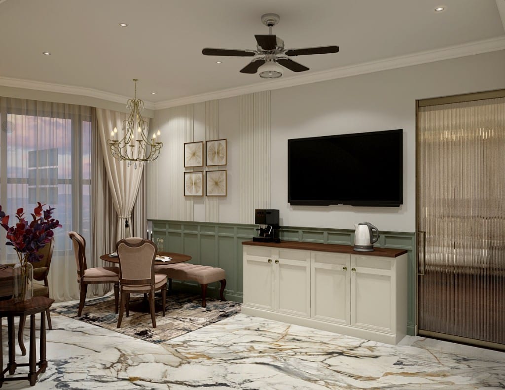 A suite dining and pantry corner, a cream sideboard with a coffee-and-kettle station beside a round table and chairs, sage wainscoting and a crystal chandelier on a book-matched marble floor