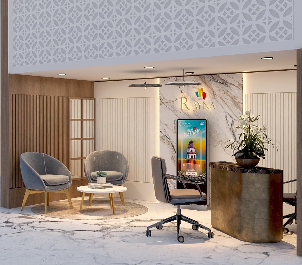 The waiting lounge of the travel desk, soft grey velvet chairs and a round table on a book-matched marble floor under disc pendant lighting