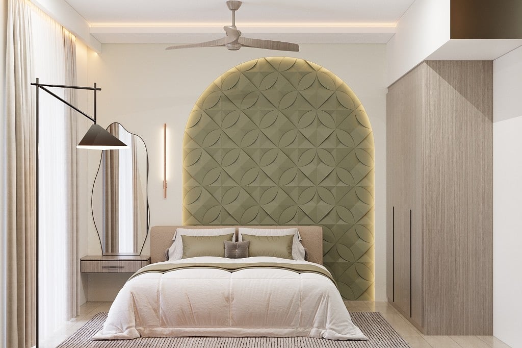 Wide view of the sage-green guest room, the arched petal-pattern headboard backlit against a soft wall, a wavy mirror over a floating nightstand, an olive throw and a jute rug