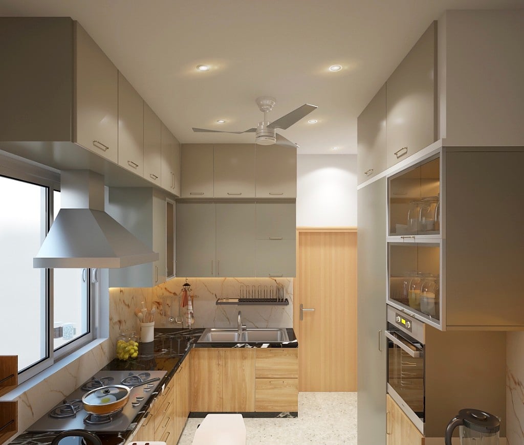 A kitchen with grey-green and warm-wood cabinetry, black stone counters, a marble backsplash, a chimney hood and a built-in oven with glass-fronted upper storage