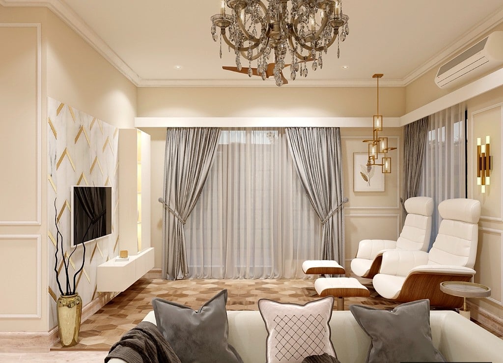 The classic living room with panelled walls, a crystal chandelier, grey drapery, white leather recliners and a marble-and-gold television wall