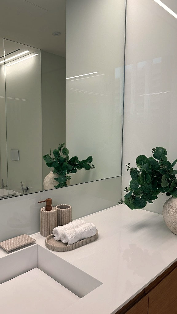 Powder bathroom in soft white, with ribbed accessories and eucalyptus